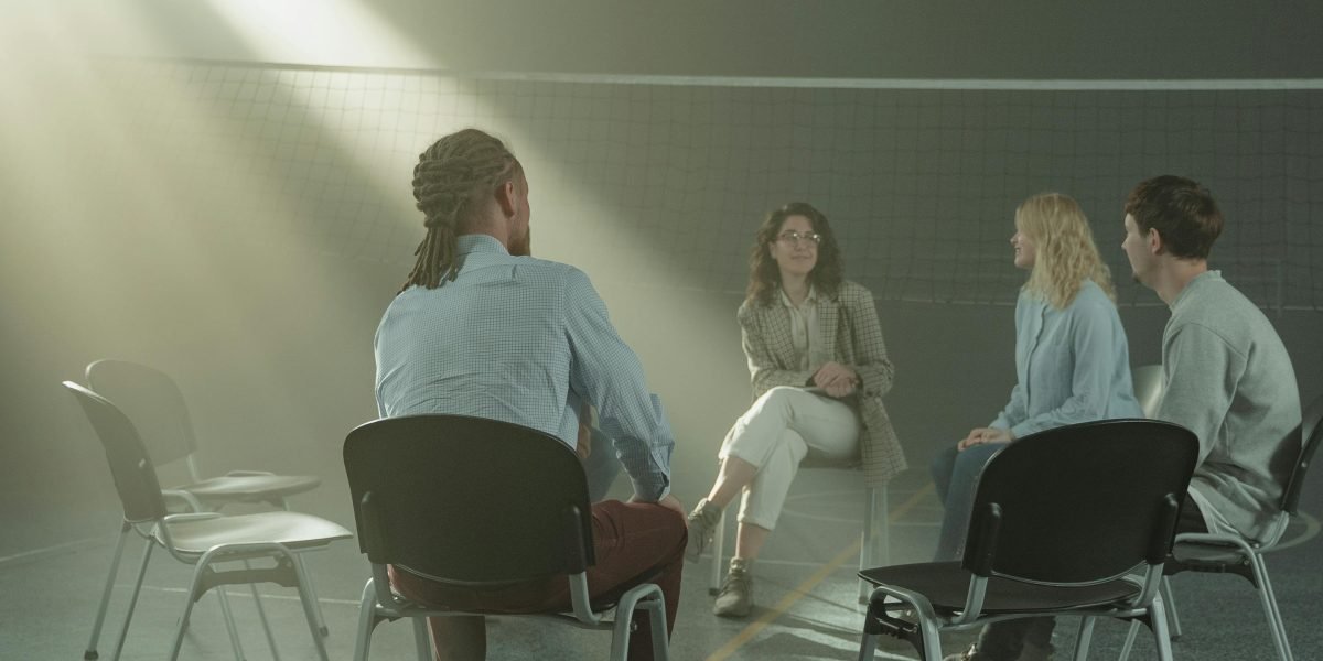 A group of people offers empathetic support to someone, emphasizing the importance of community in mental health journeys.