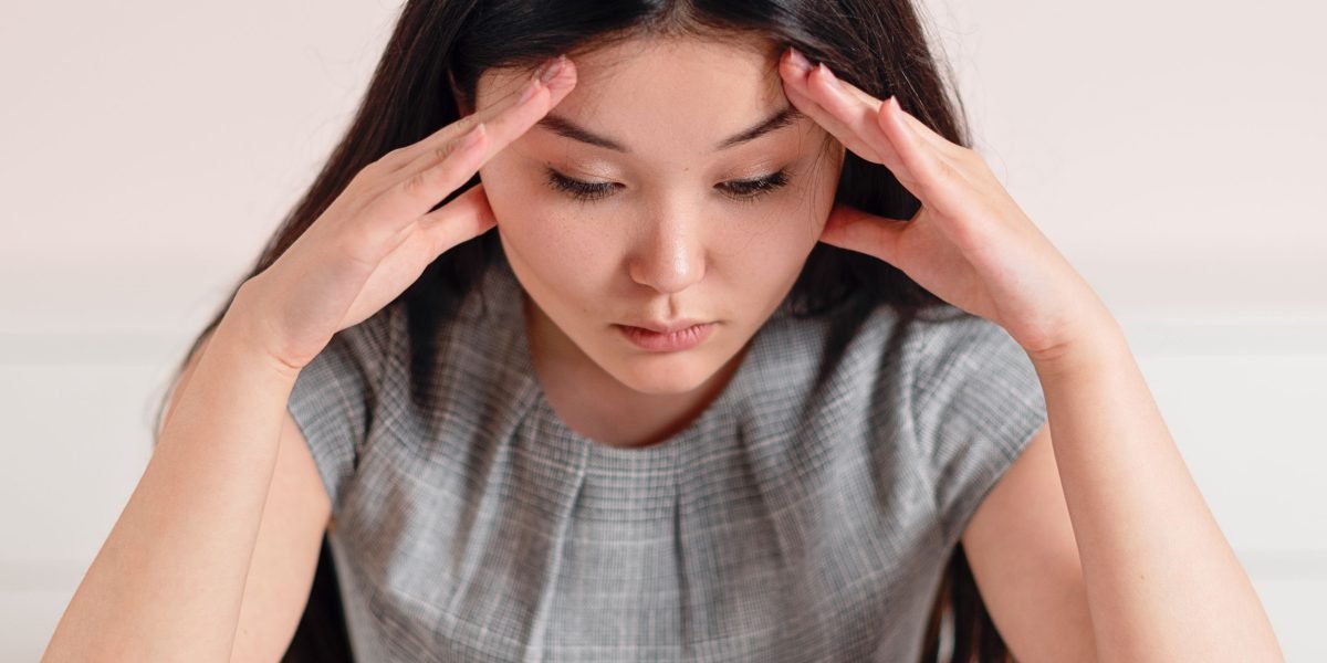 A person looks thoughtful and slightly overwhelmed, reflecting the internal struggle and confusion often associated with unexplained physical symptoms.