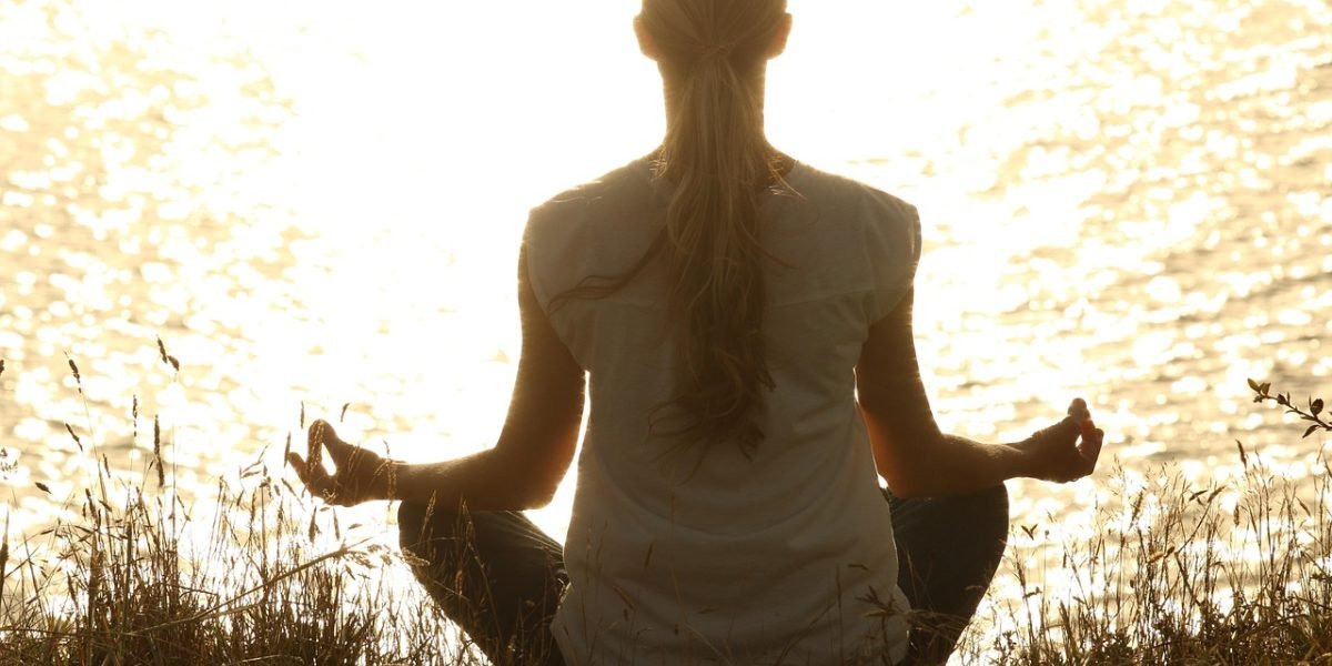 A person practicing yoga outdoors, symbolizing effective self-care and mindfulness techniques for managing stress and improving well-being.