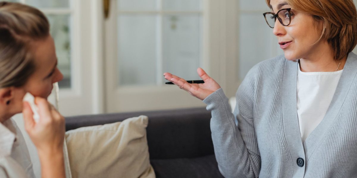 A compassionate caregiver actively listening to someone expressing their feelings, showing support.
