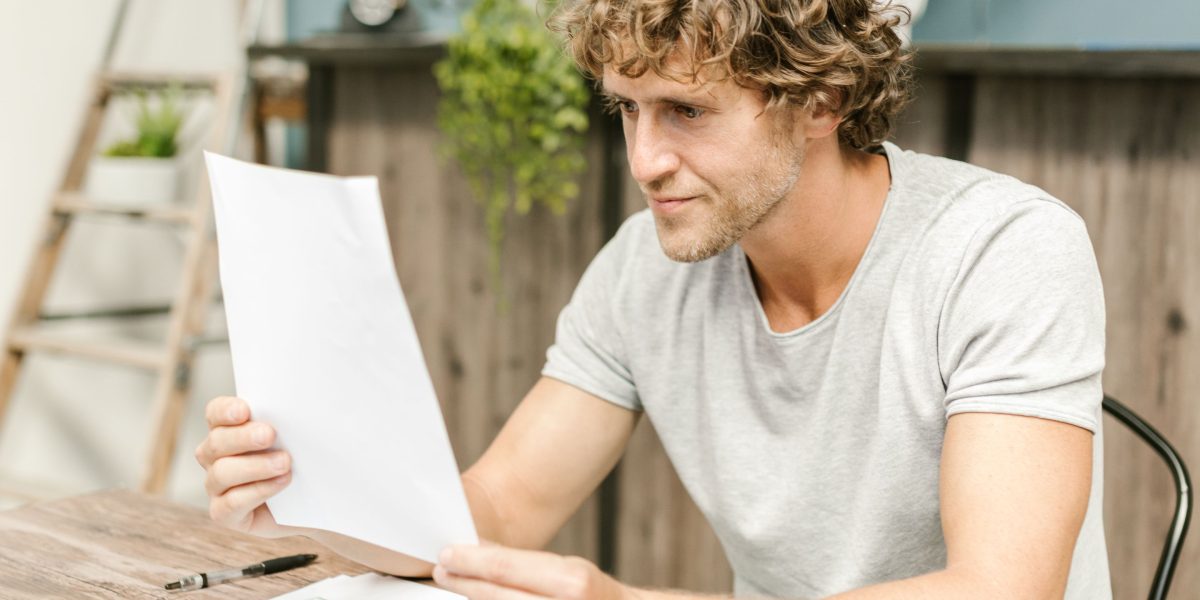 A person carefully reviewing documents, symbolizing the process of evaluating online therapy quality, safety, and privacy.