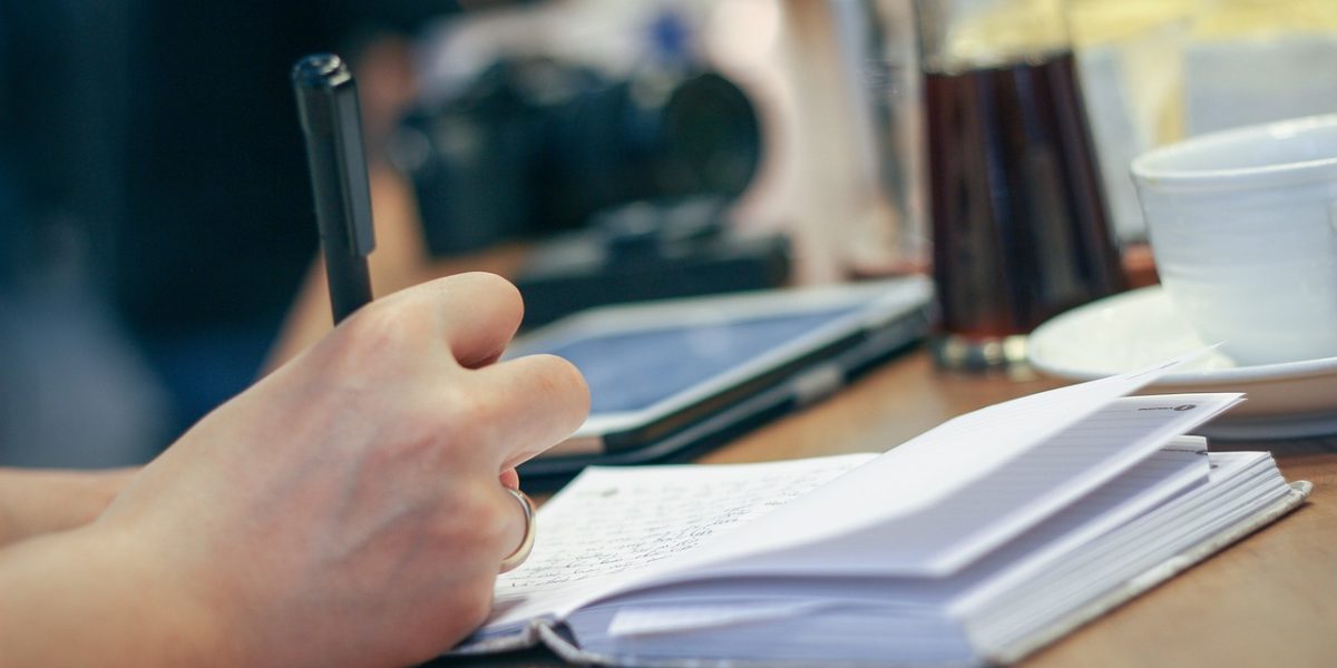 A person thoughtfully writing notes, symbolizing the active process of learning and building a mental health vocabulary.