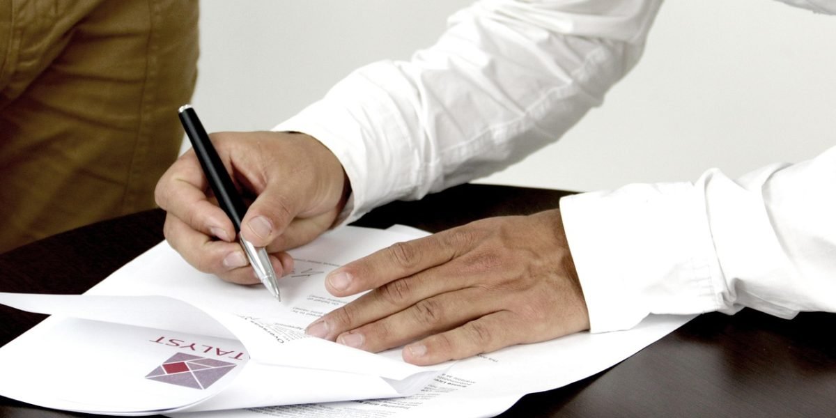 A person thoughtfully reviewing documents, representing the process of navigating eligibility and enrollment paperwork.